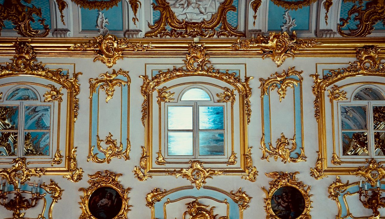 Luxurious gold-trimmed renaissance architecture with ornate windows in a museum setting.